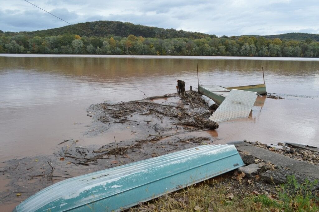 A river flood that has destroyed a couple of boats, and a house